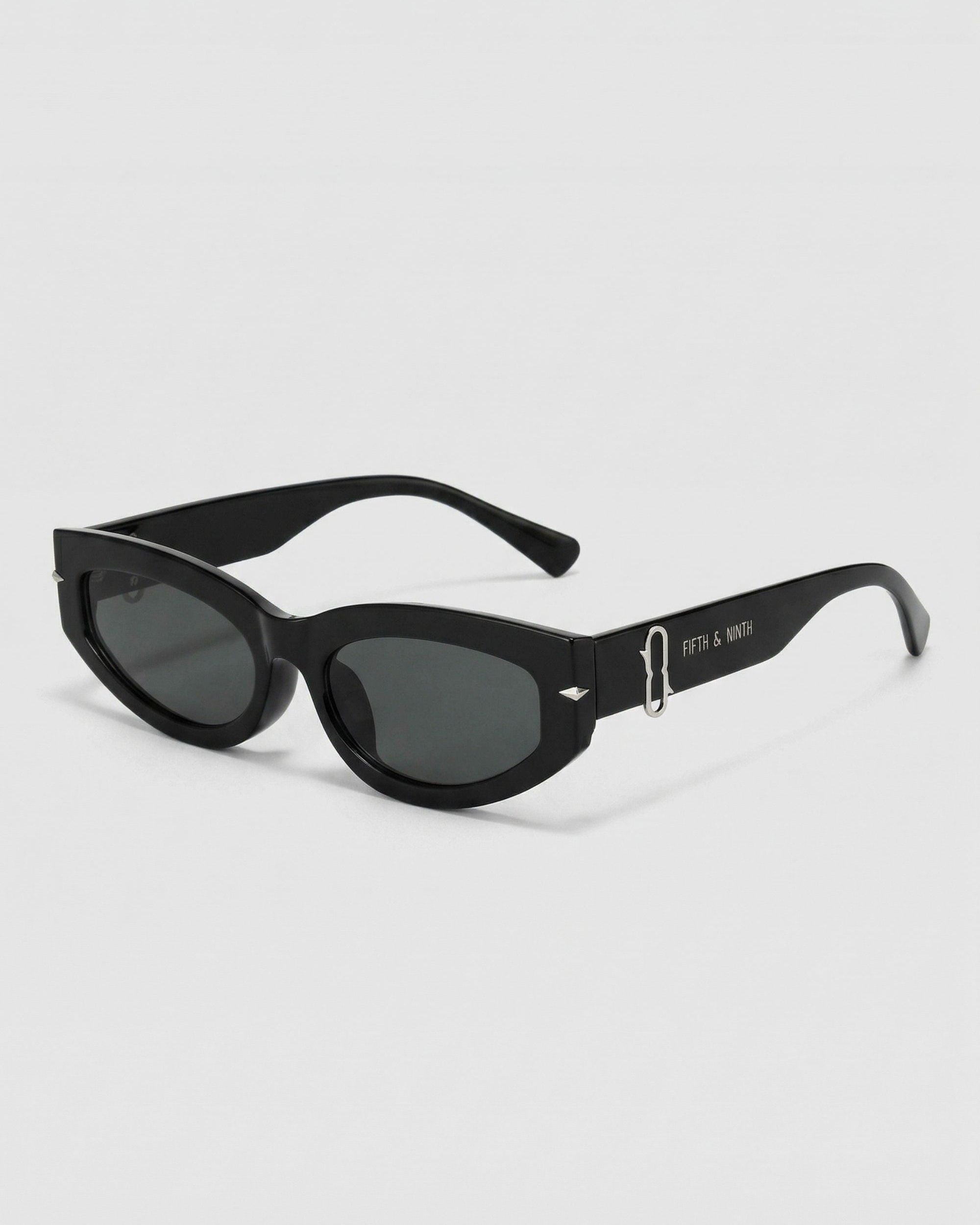 Black sunglasses with gold accents on a white background