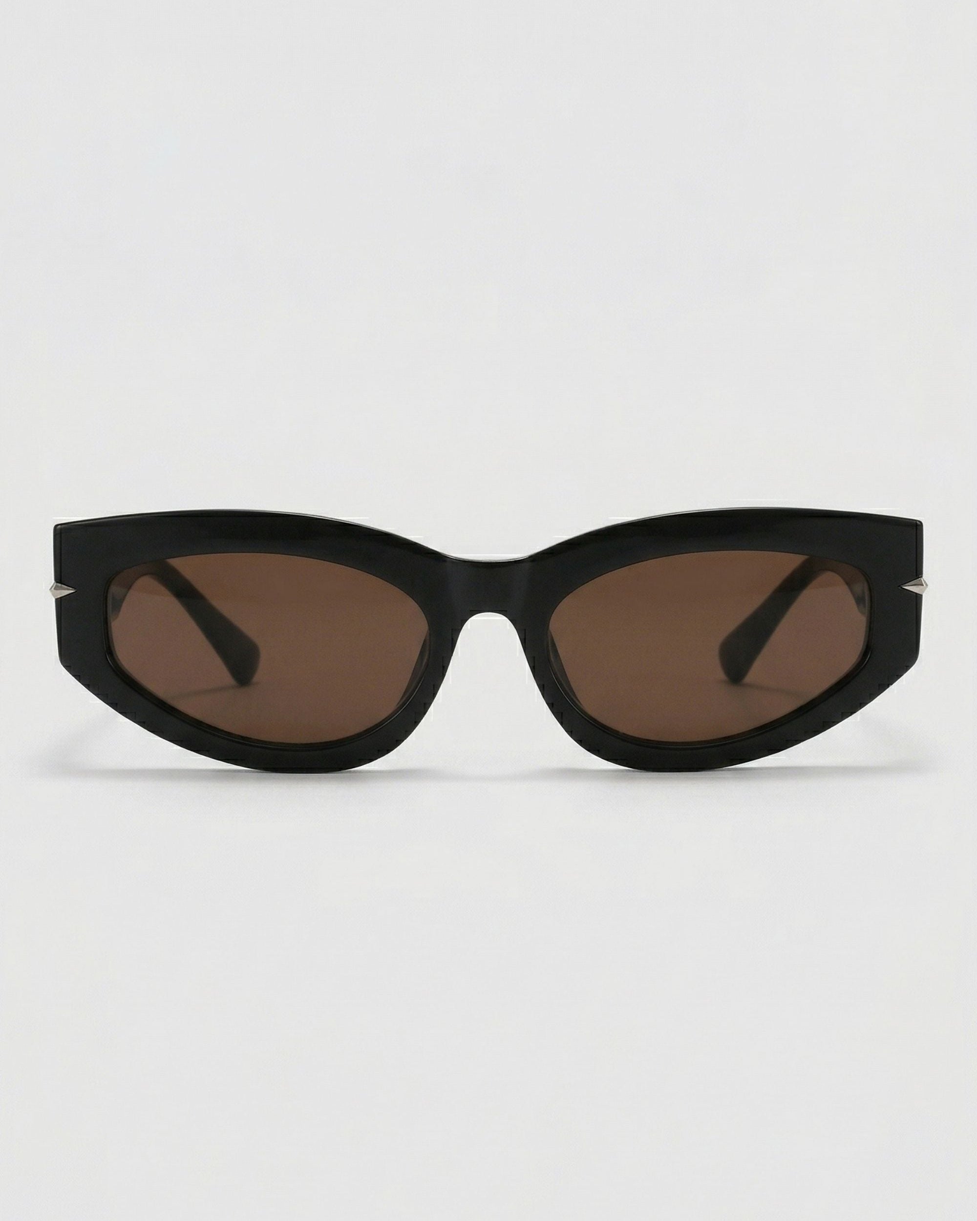 Black cat-eye sunglasses with brown lenses on a light gray background