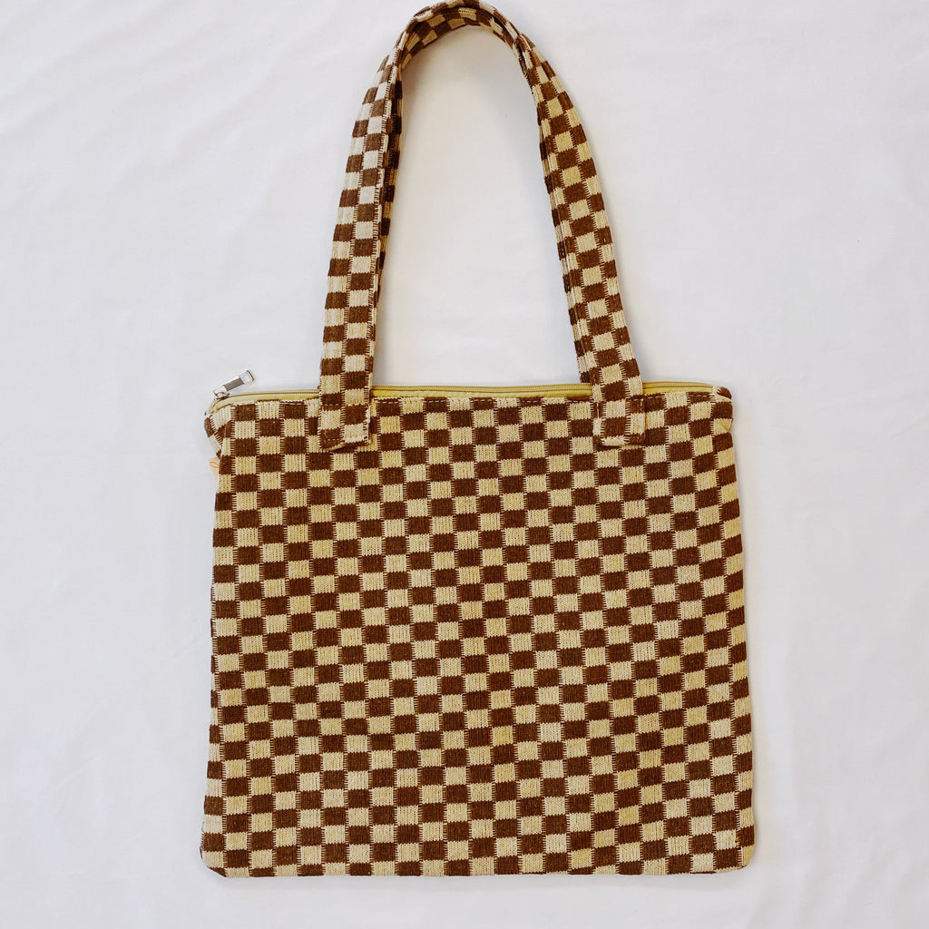 Checkered tote bag with a brown and beige pattern on a white background