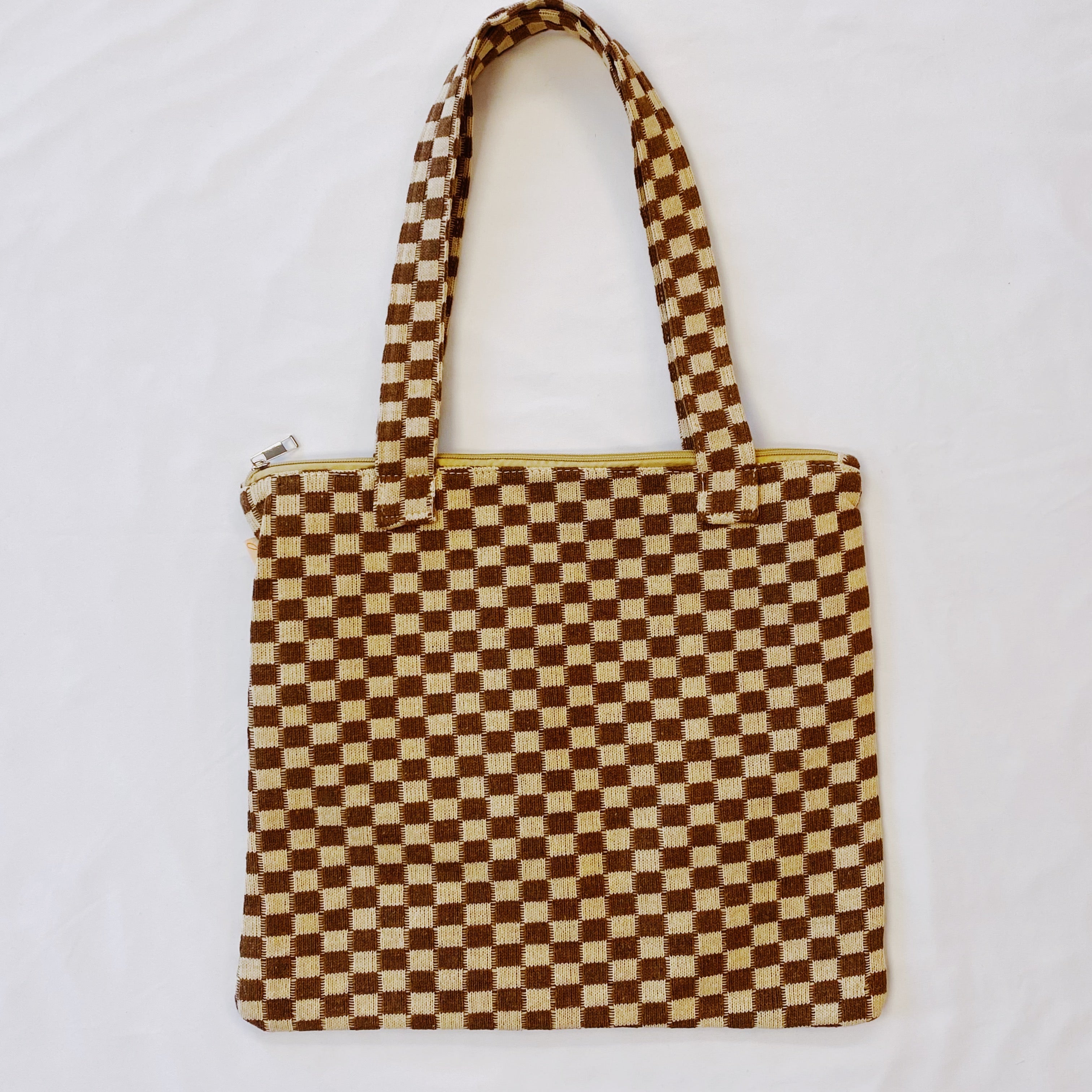 Checkered tote bag with a brown and beige pattern on a white background