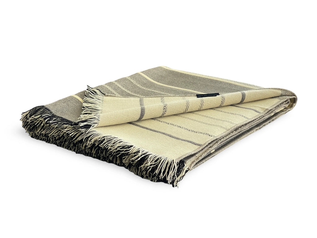 Folded plaid blanket with striped pattern on a white background