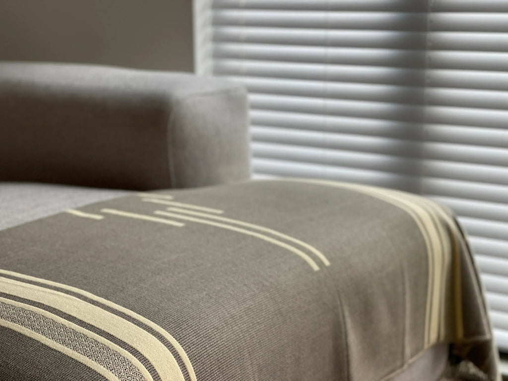 Gray fabric with beige stripes on a surface, with a blurred background
