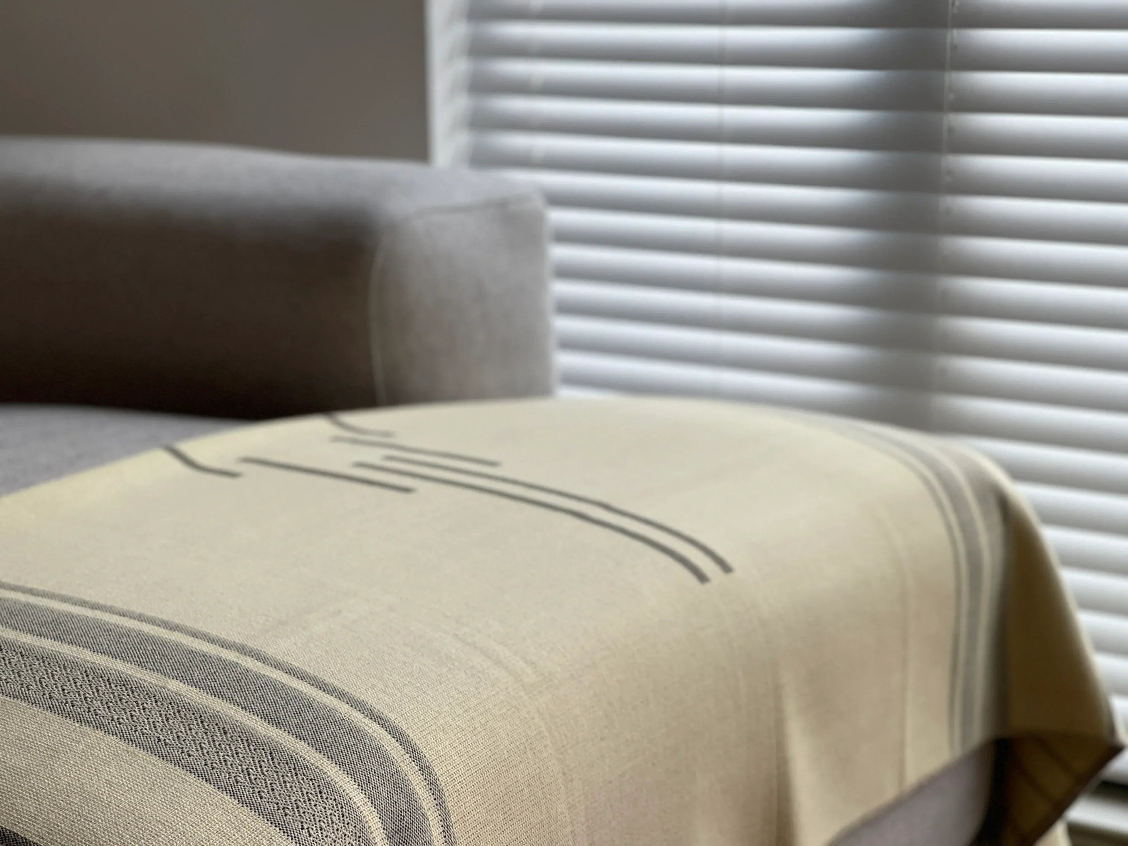 Close-up of a textured fabric with a neutral color palette, featuring horizontal stripes.