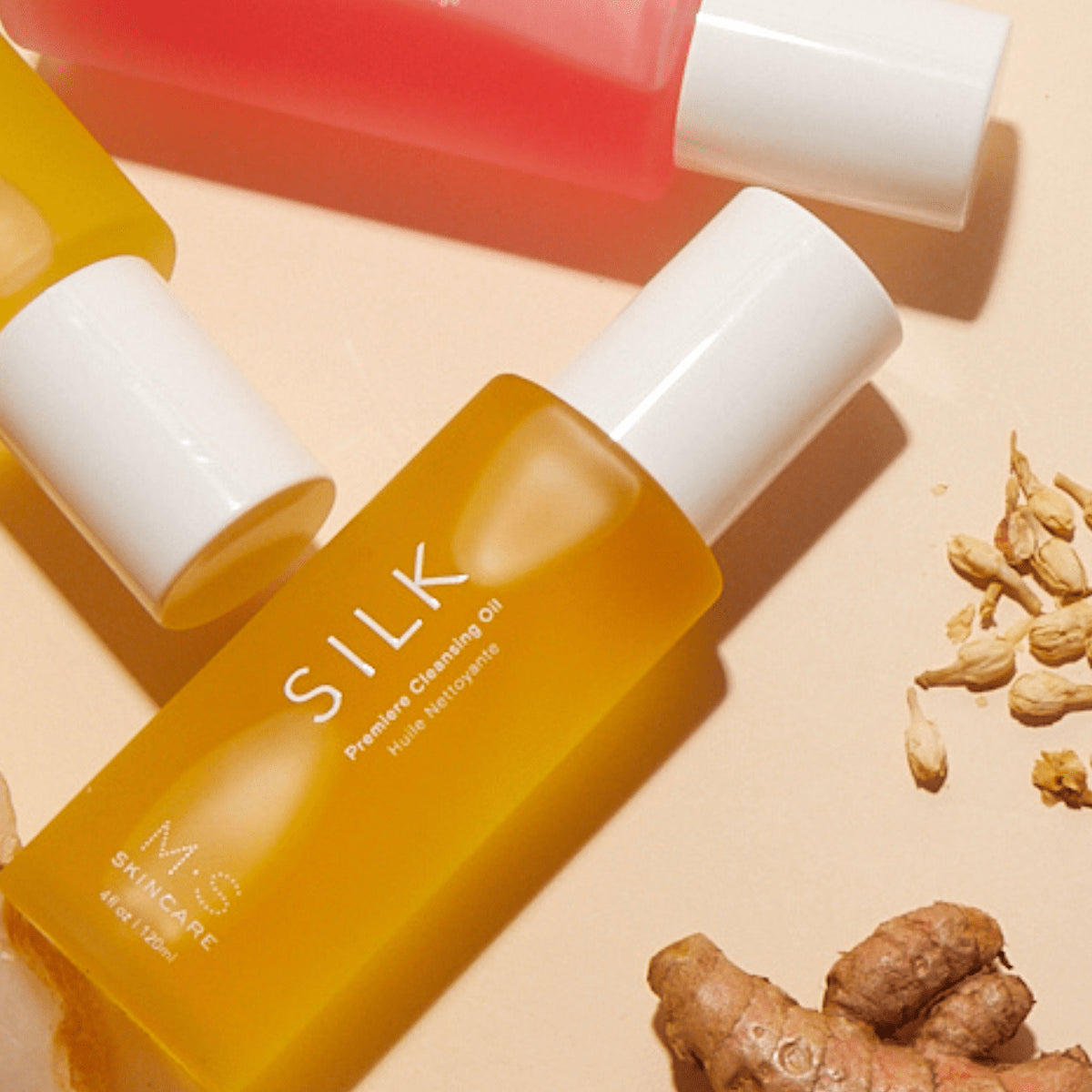 Bottle of M&S Silk Premier Cleansing Oil with ingredients on a beige background