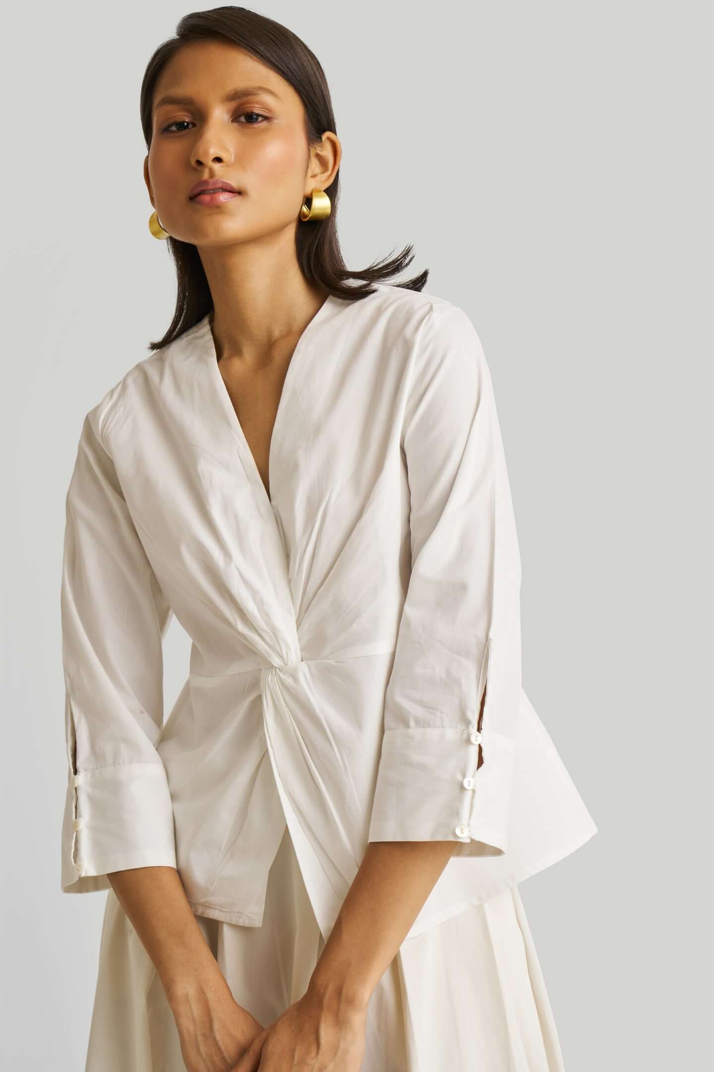 Woman wearing a white top with a plain background