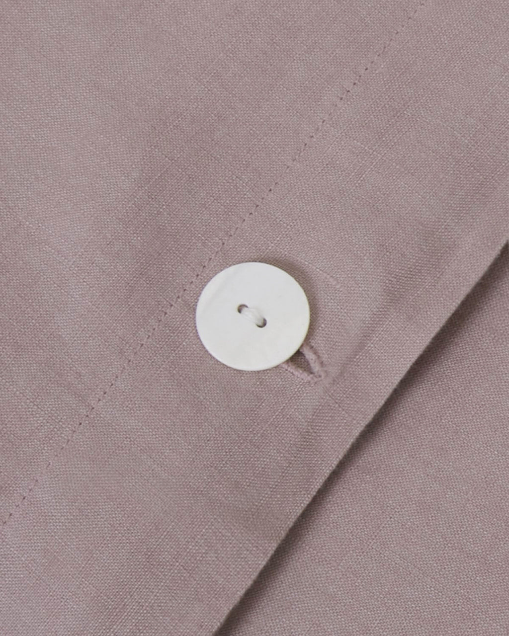 Close-up of a button on a light brown fabric