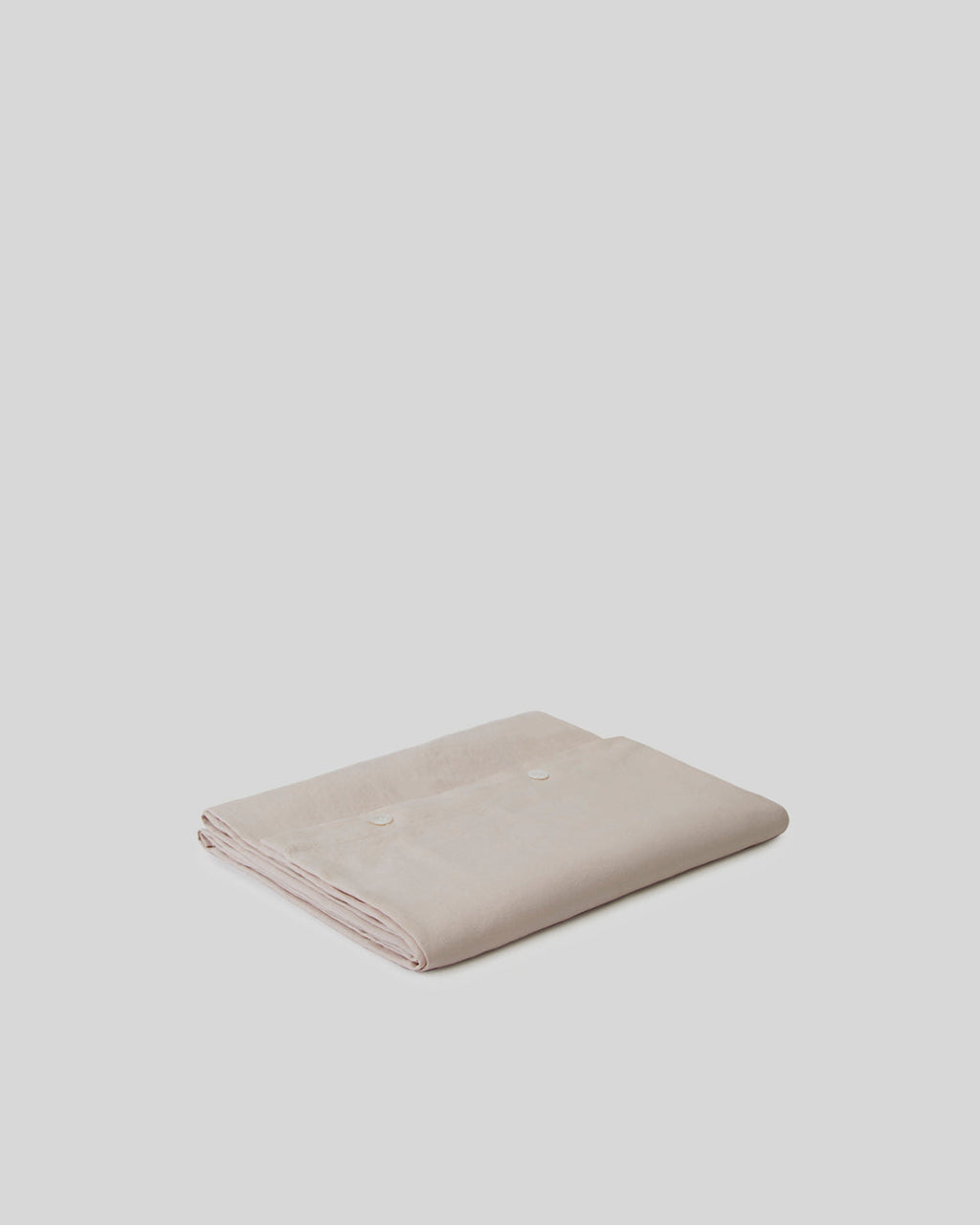 Folded beige fabric on a light gray background