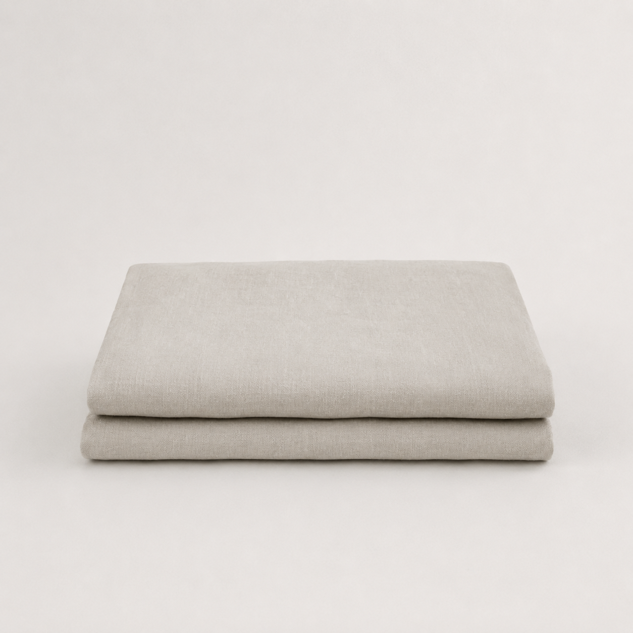 A folded light gray fabric item, likely a sheet or blanket, displayed on a clean white background.
