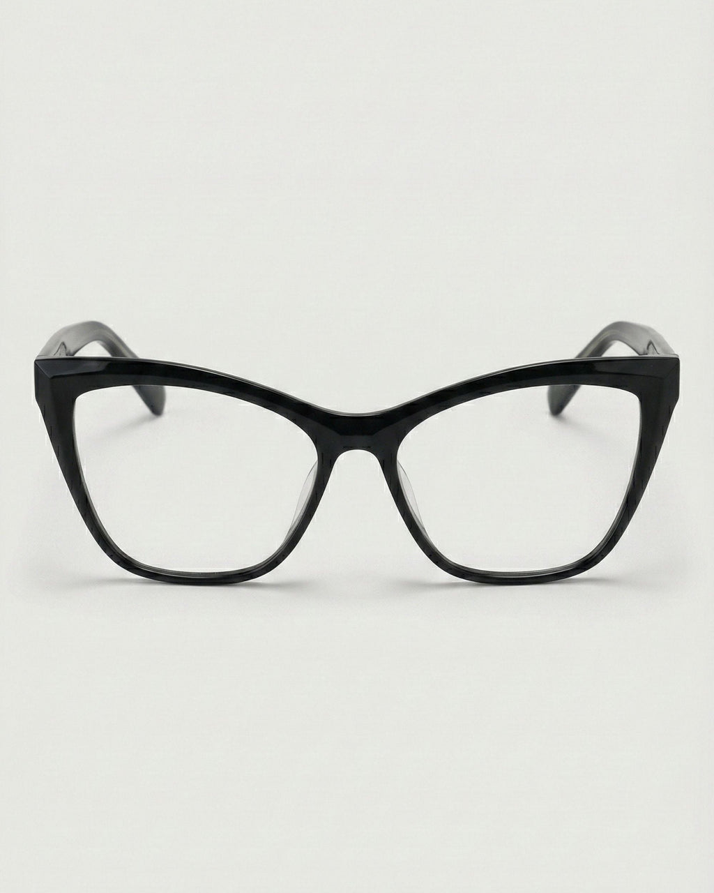 Black cat-eye glasses on a light gray background