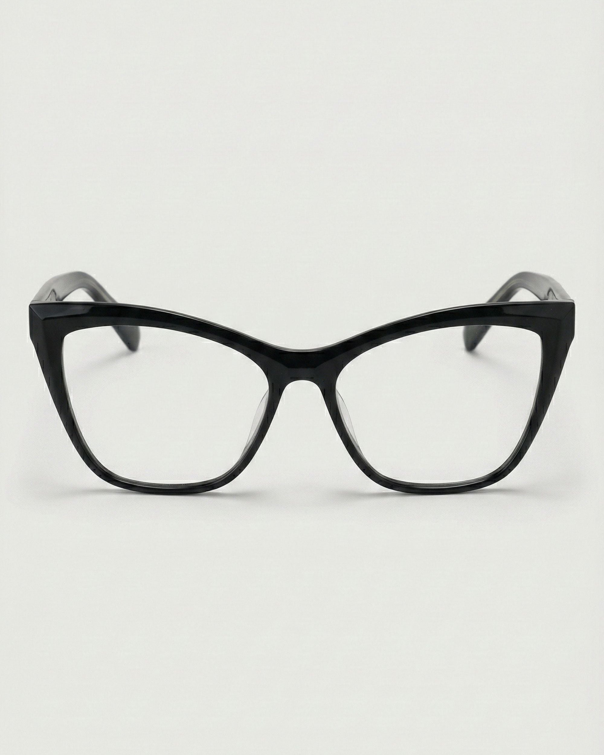 Black cat-eye glasses on a light gray background