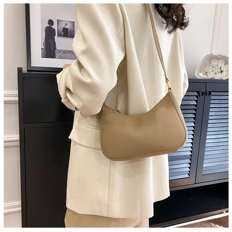 Person wearing a beige outfit with a matching handbag in an indoor setting.