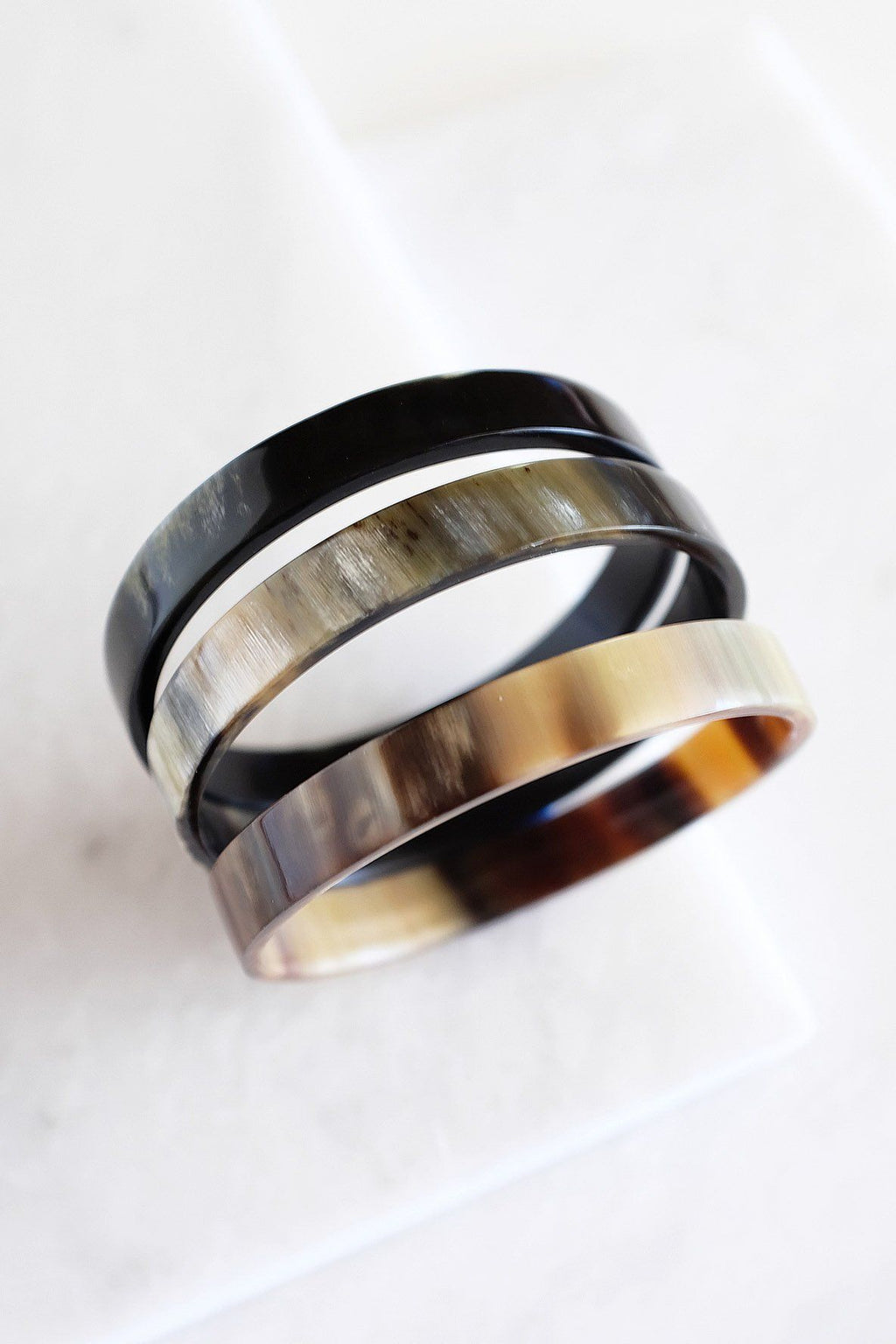Two rings with black, silver, and gold bands on a white background