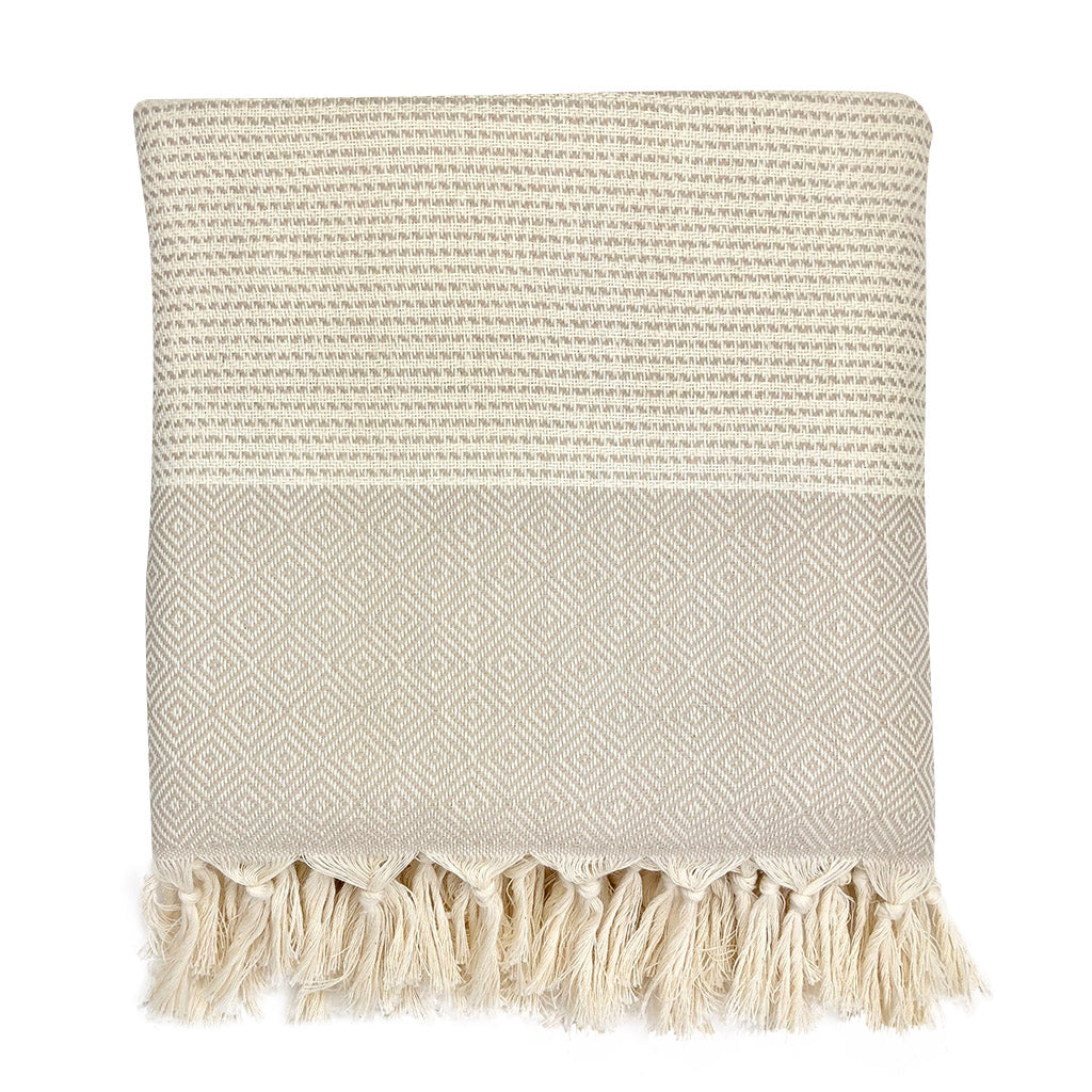 Textured throw blanket with tassels on a white background