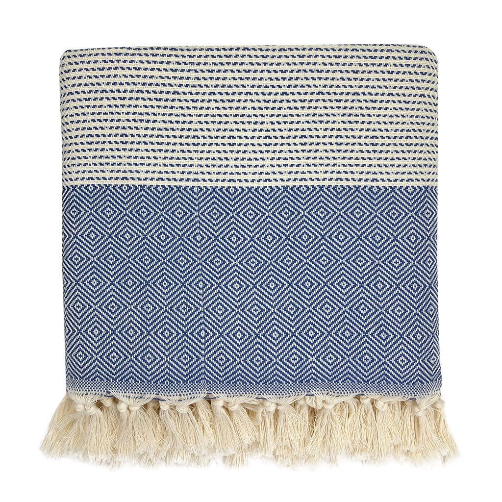 Woven blanket with blue geometric pattern and white fringe on a white background